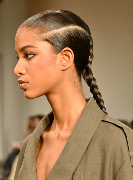 A model at Tory Burch wears a braid with a horizontal part along the side of her head